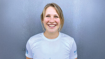 Eine blonde Frau lacht in die Kamera