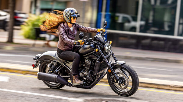 Eine Frau fährt auf einem Motorrad durch die Stadt