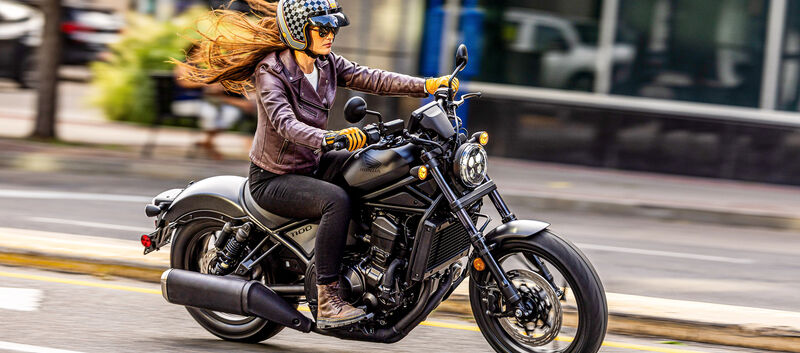 Eine Frau fährt auf einem Motorrad durch die Stadt