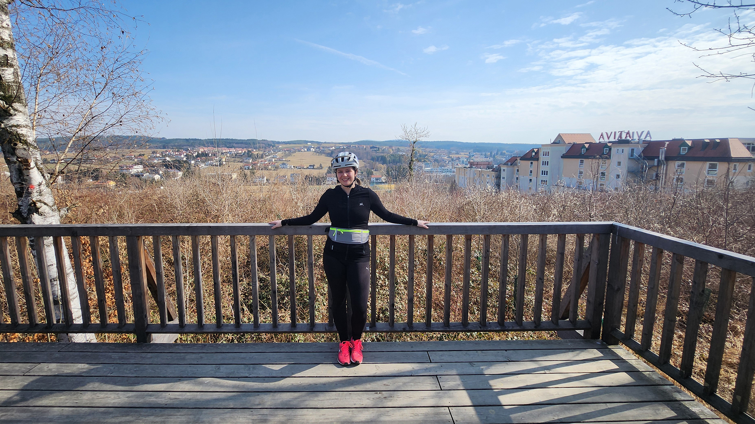 Redakteurin Verena Schauer auf der Aussichtsplattform in Bad Tatzmannsdorf. Sie steht mit dem Rücken zur Aussicht und lächelt.