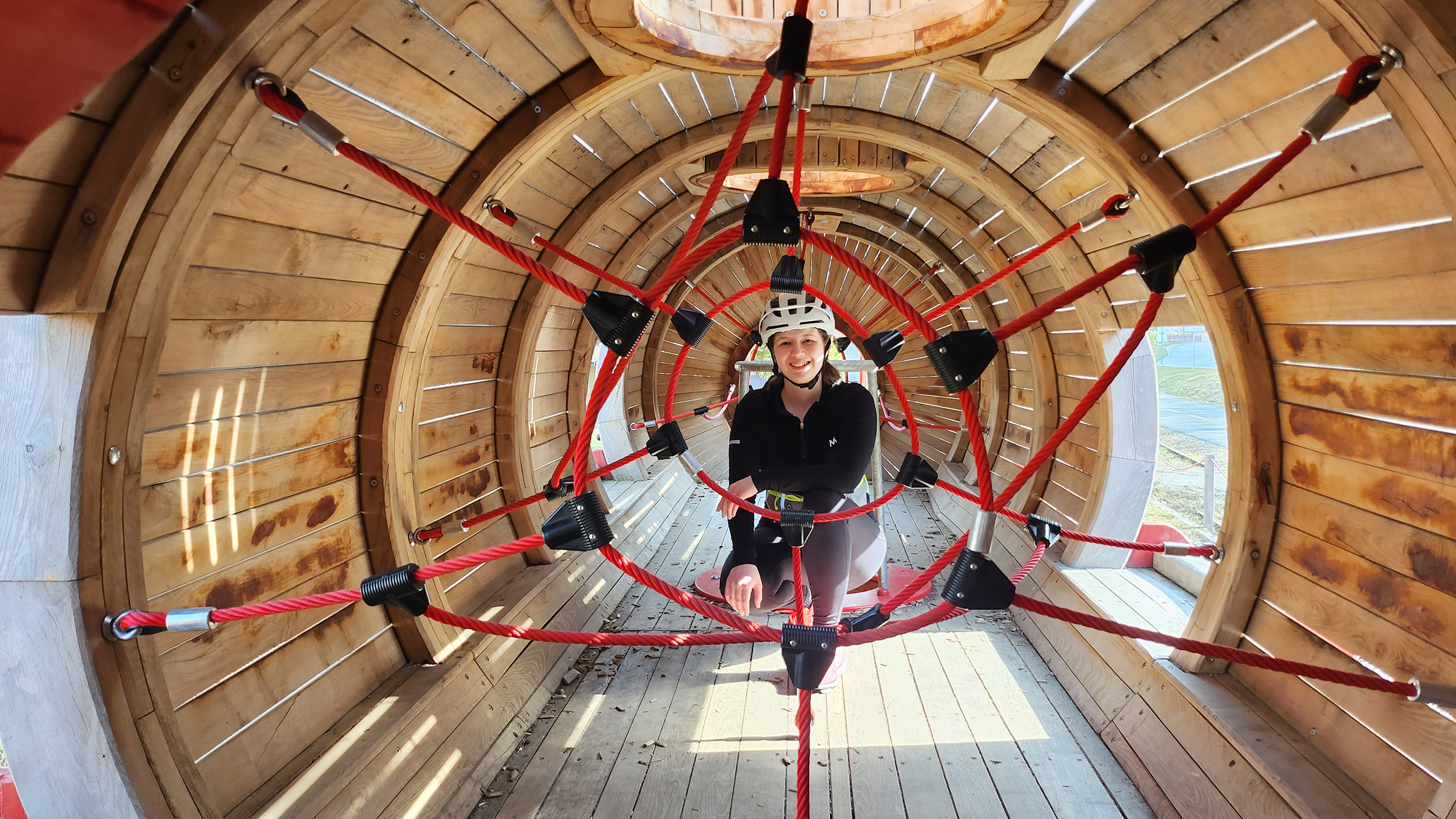 Redakteurin Verena Schauer im Holzzug. Man sieht Kletterseile um sie herum.