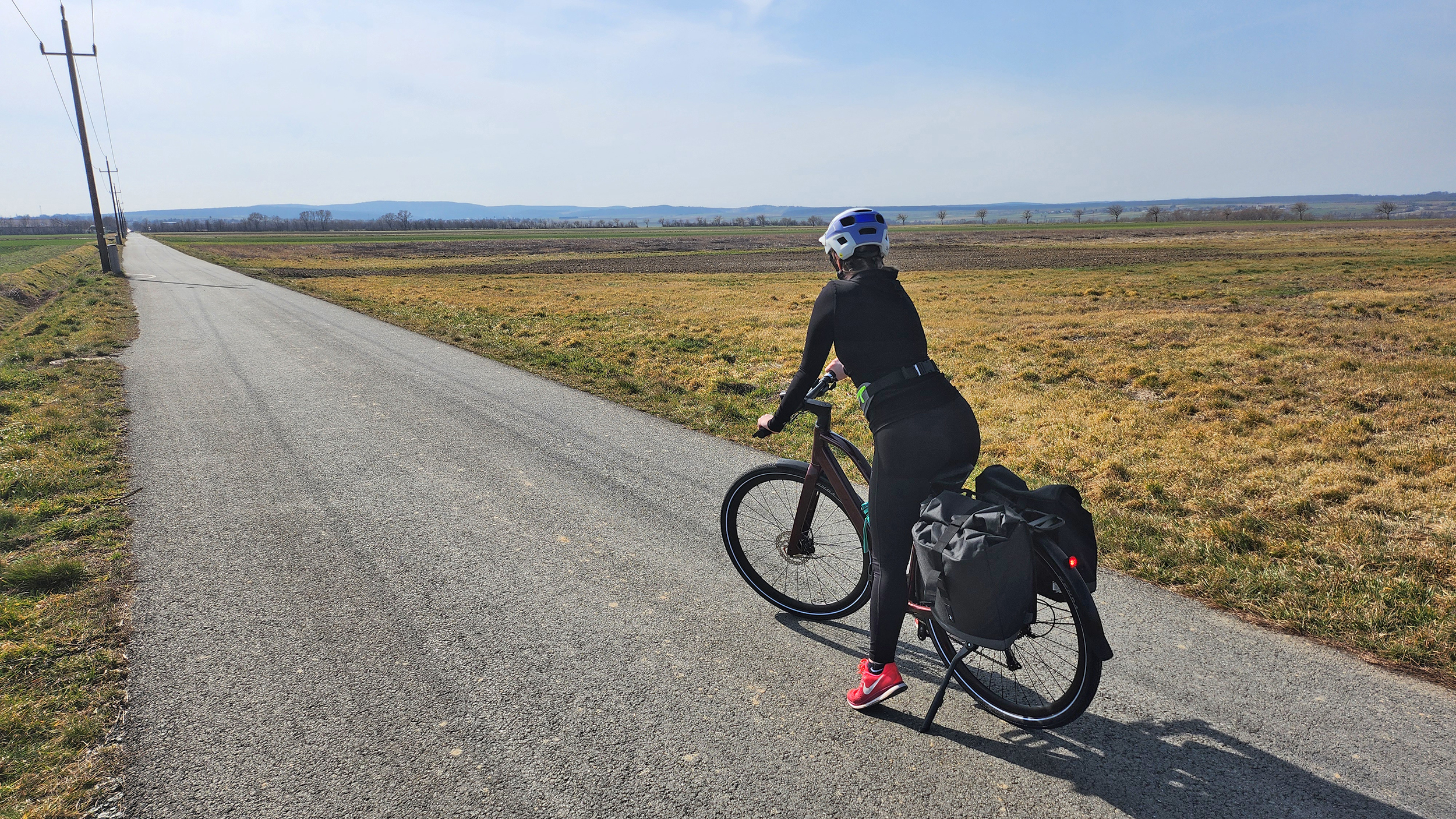 Redakteurin Verena Schauer sitzt am Rad und schaut auf den Bahntrassen-Radweg. Man sieht sie von hinten. 