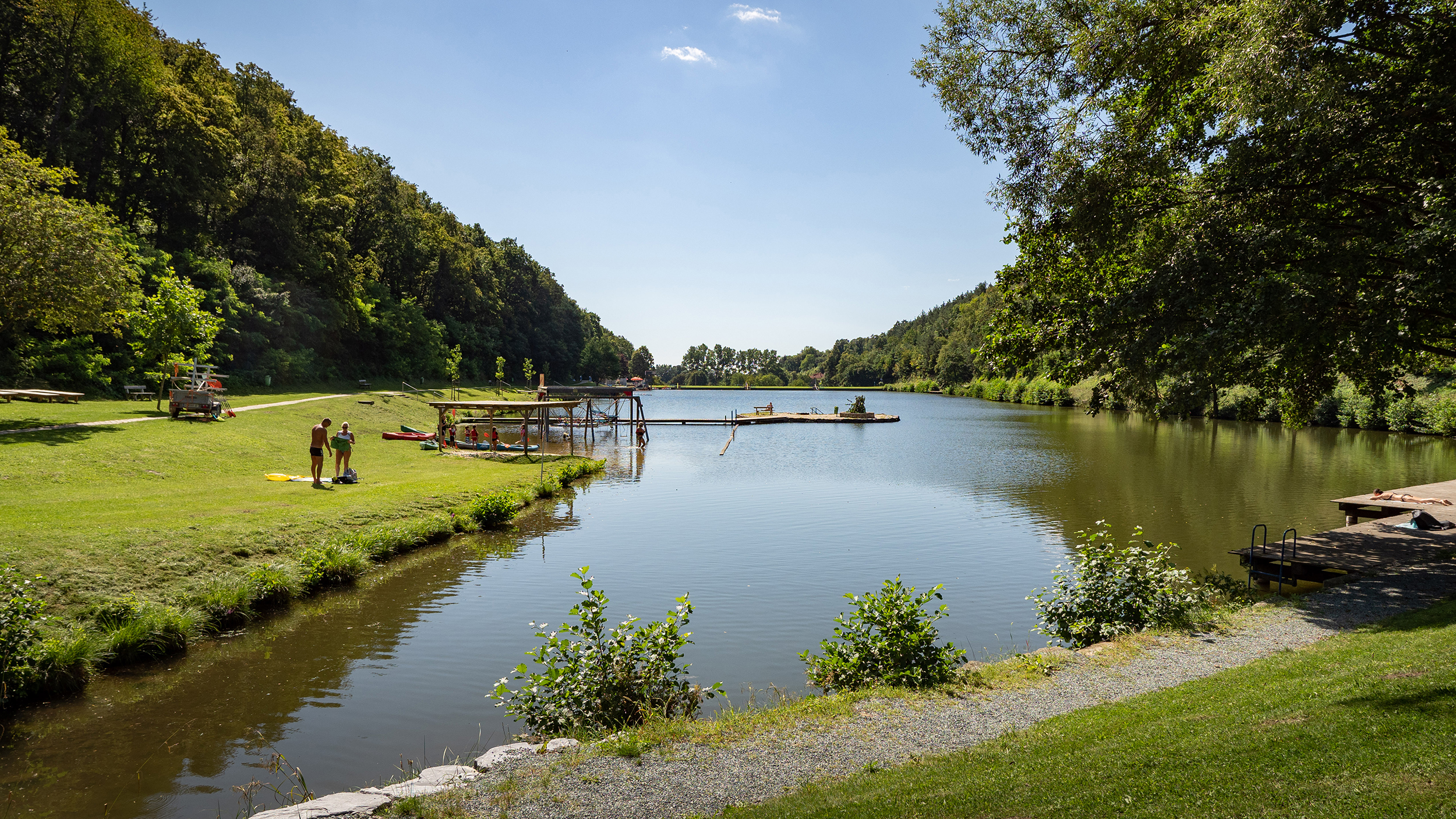 Der Badeesee in Rechnitz im Sommer. Man sieht vereinzelt Badegäste.