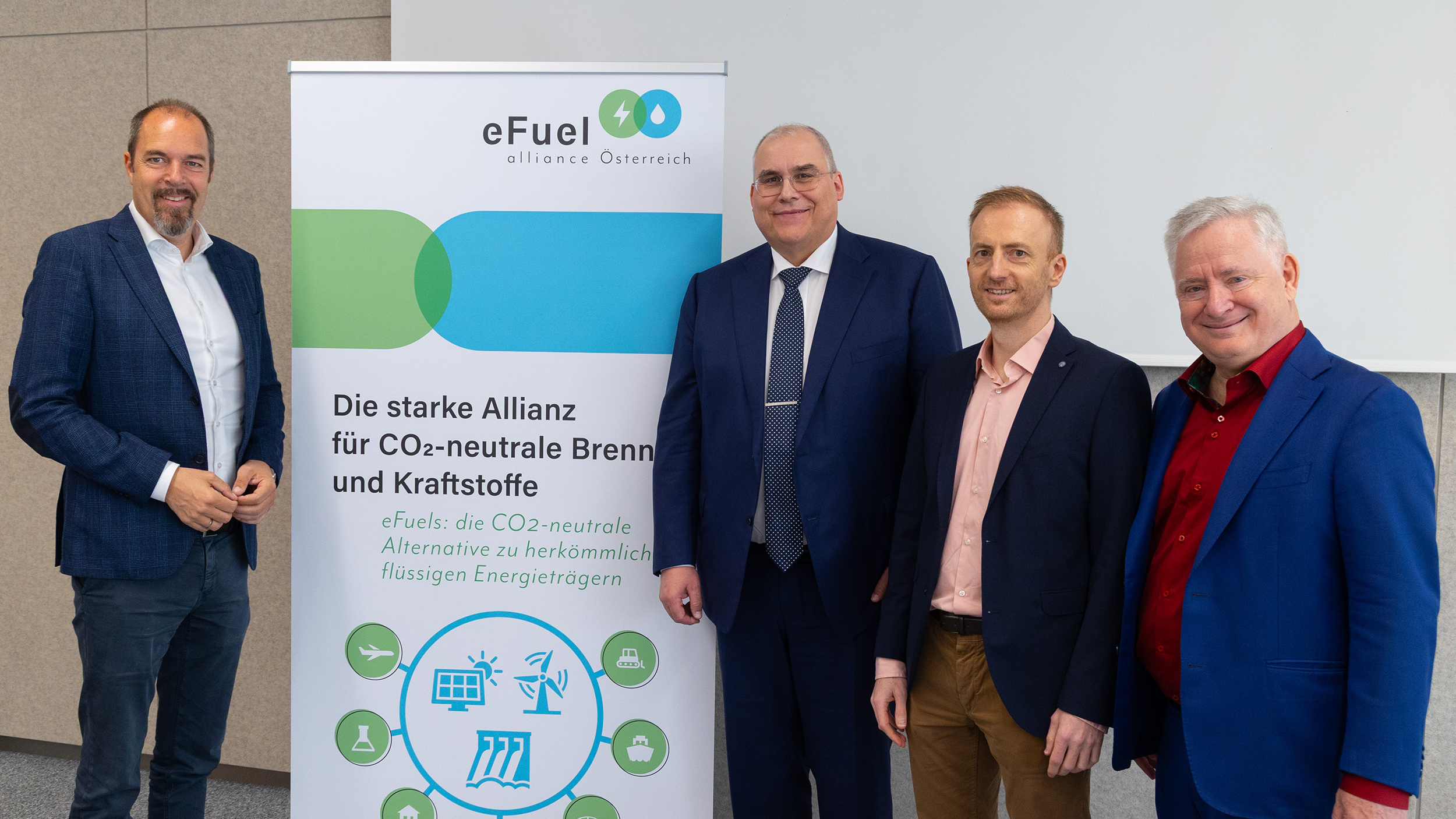 Vier Männer im Anzug bei einer Präsentation