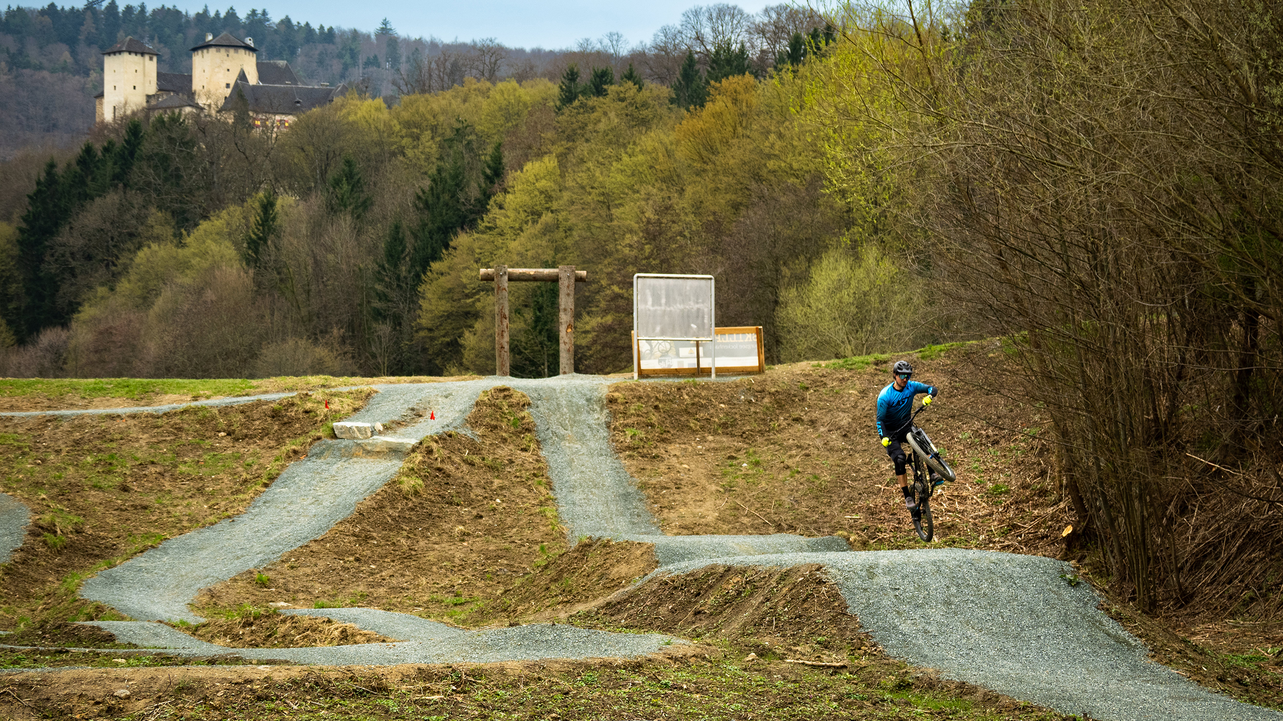 Ein Radfahrer springt in einem Bikepark über einen Hügel