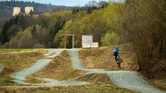 Ein Radfahrer springt in einem Bikepark über einen Hügel