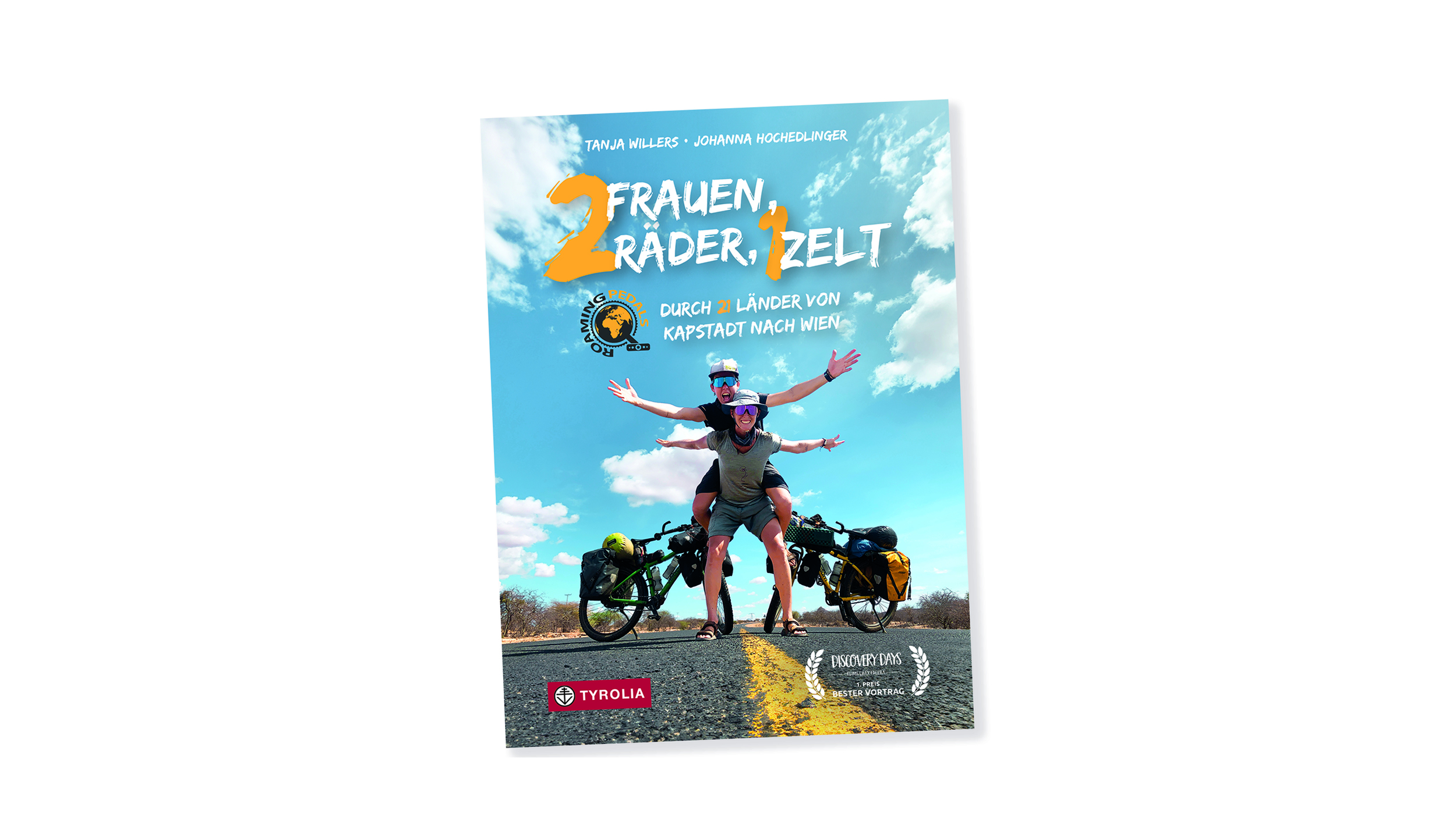 Buchcoverbild "2 Frauen, 2 Räder, 1 Zelt". Darauf sind 2 Frauen zu sehen, die vor ihren Rädern auf einer Straße stehen. Die eine hat die andere huckepack am Rücken.
