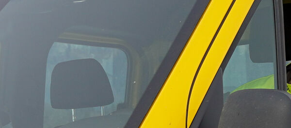 Auf dem Bild sieht man einen jungen Pannenfahrer des ÖAMTC. Er sitzt in seinem gelben Pannenfahrzeug, schaut beim seitlichen Fenster heraus.. Er hat eine gelbe Jacke an.