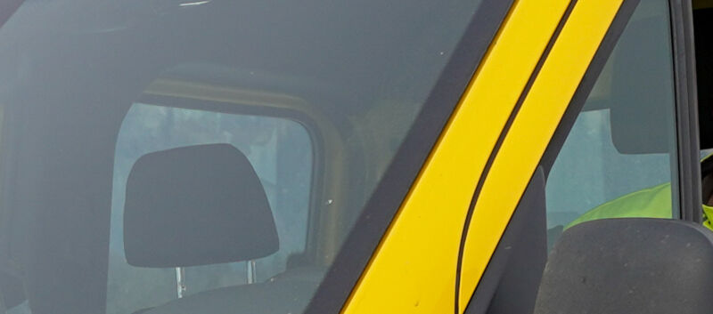 Auf dem Bild sieht man einen jungen Pannenfahrer des ÖAMTC. Er sitzt in seinem gelben Pannenfahrzeug, schaut beim seitlichen Fenster heraus.. Er hat eine gelbe Jacke an.