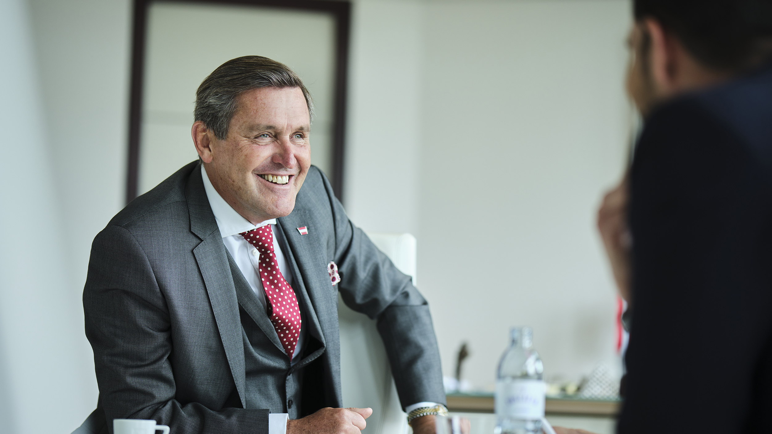 Portrait von Verkehrsminister Peter Hanke lachend im Interview.