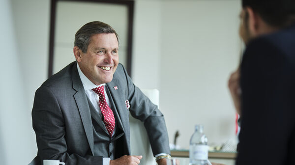 Portrait von Verkehrsminister Peter Hanke lachend im Interview.