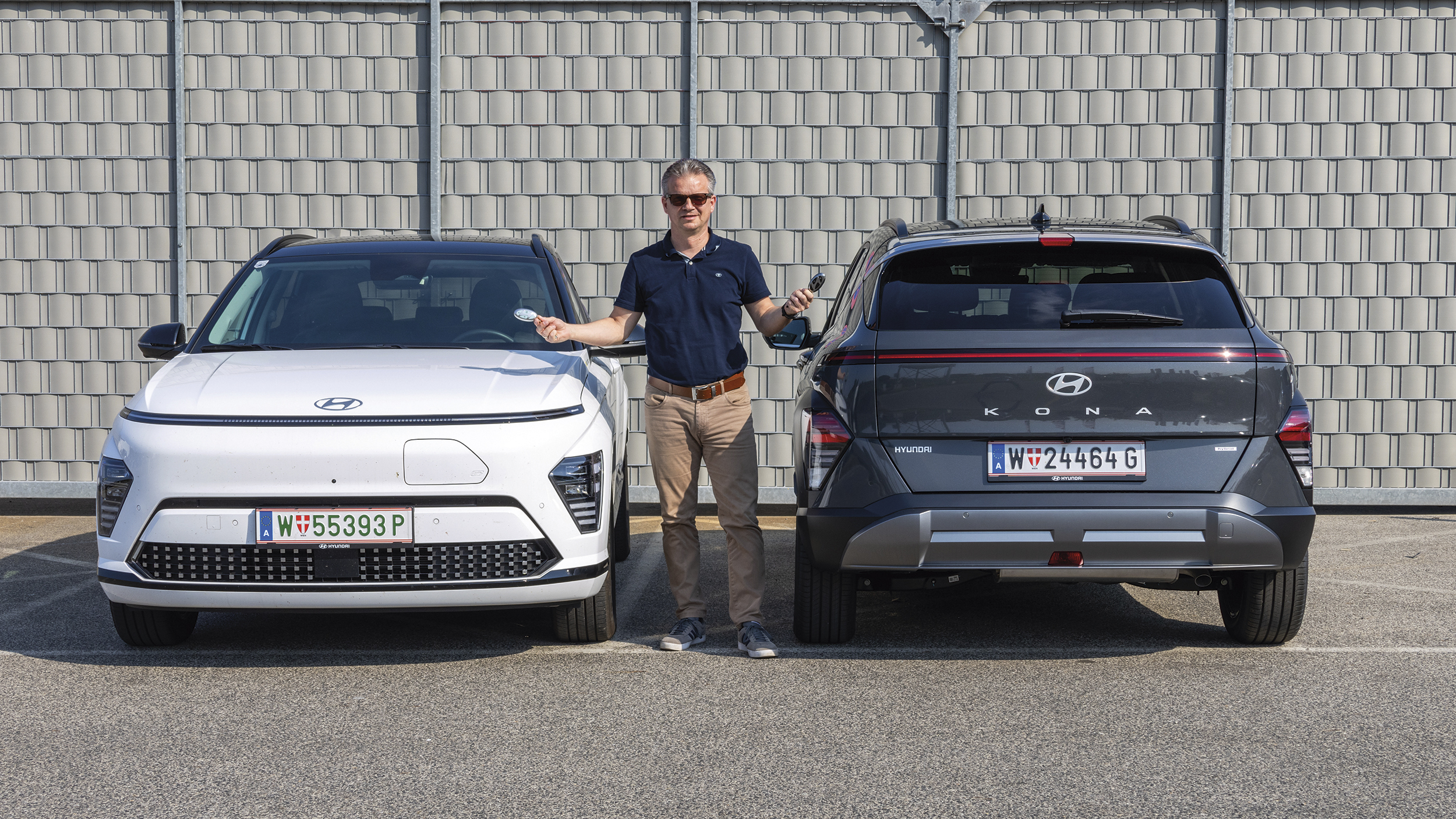 Hyundai Kona in grau und weiß, dazwischen ein Mensch