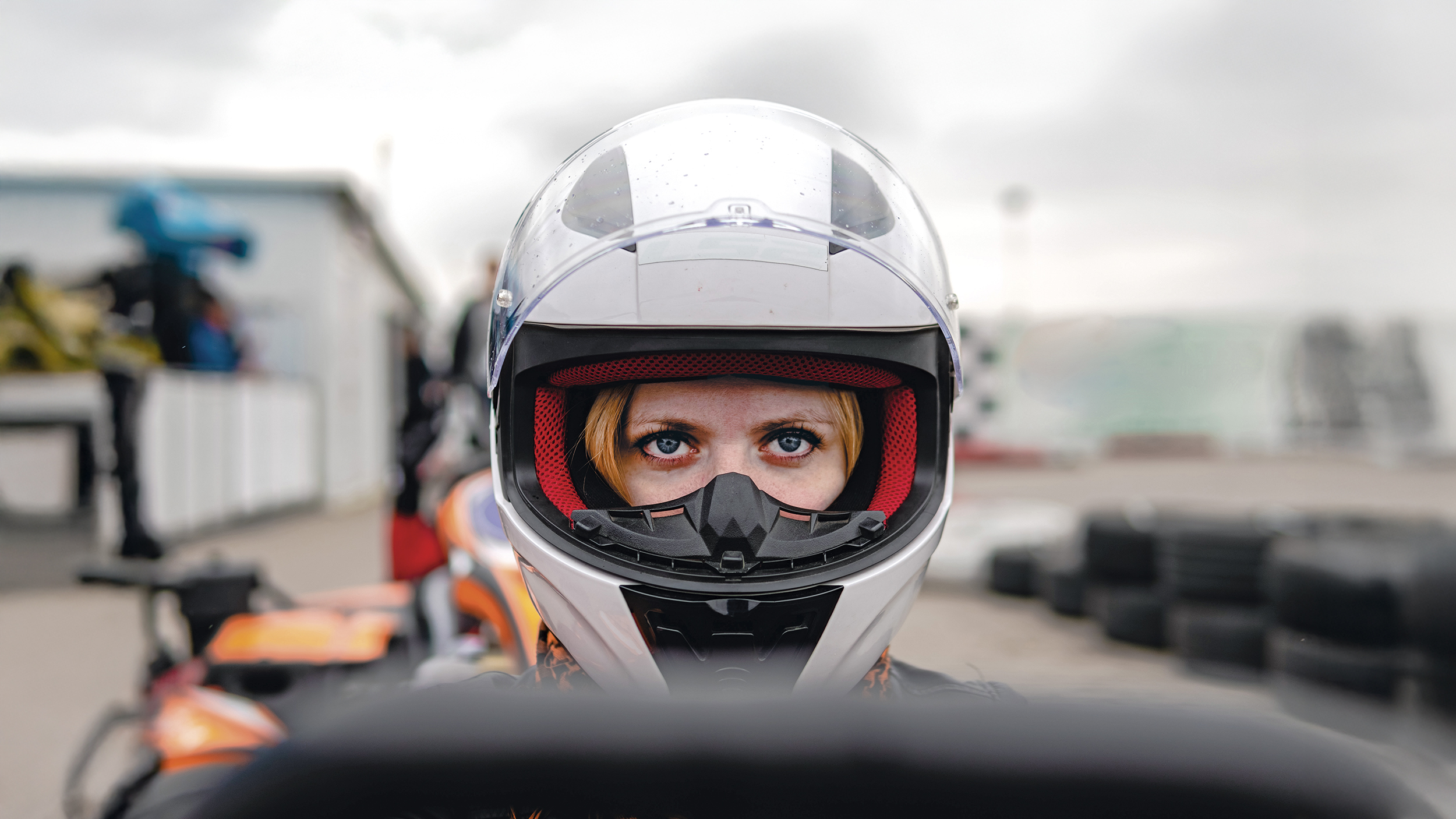 Frau mit weißem Sturzhelm im Cockpit