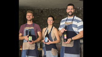2 Weinbauer und eine Weinbäuerin mit einer Weinflasche in der Hand auf der Insel Hvar.