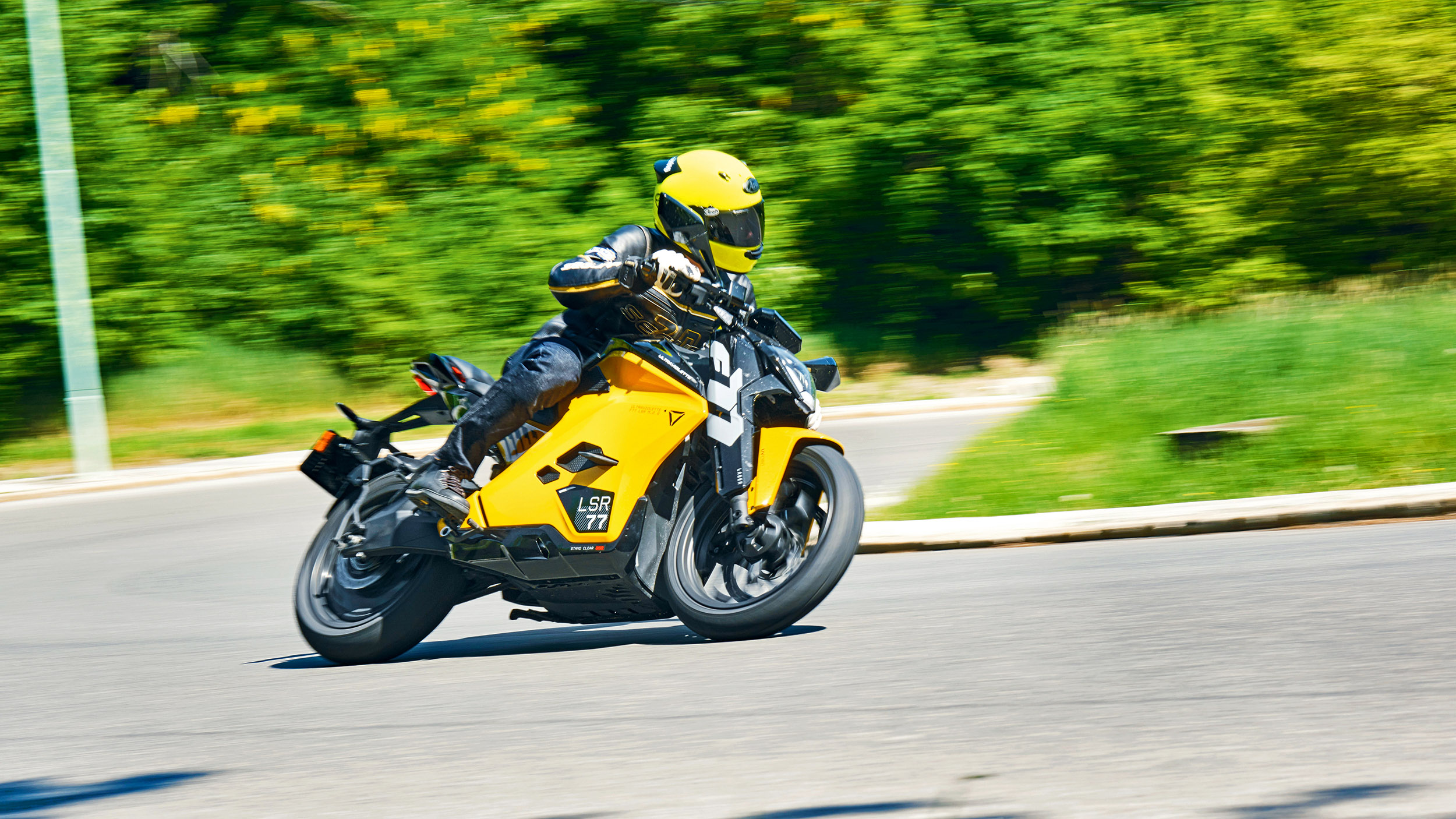 Gelbes Motorrad fährt in Schräglage um Kurve