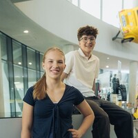 Ferialpraktikum Zwei Jugendliche, Mädchen links, Bursche rechts, im Umfeld des Schalterbereiches eines ÖAMTC Stützpunktes