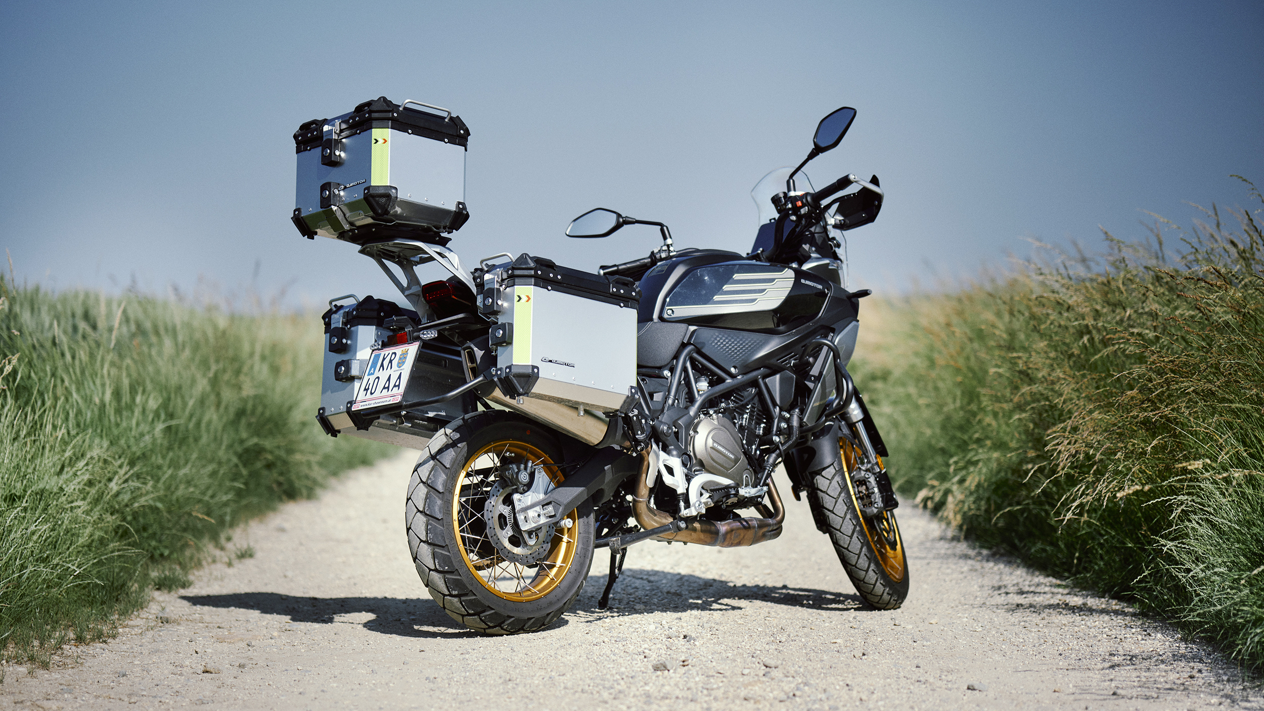 Die Mittelklasse Reiseenduro QJ SRT 700 SX mit drei am Heck montierten Alu-Koffern von schräg rechts hinten fotografiert.