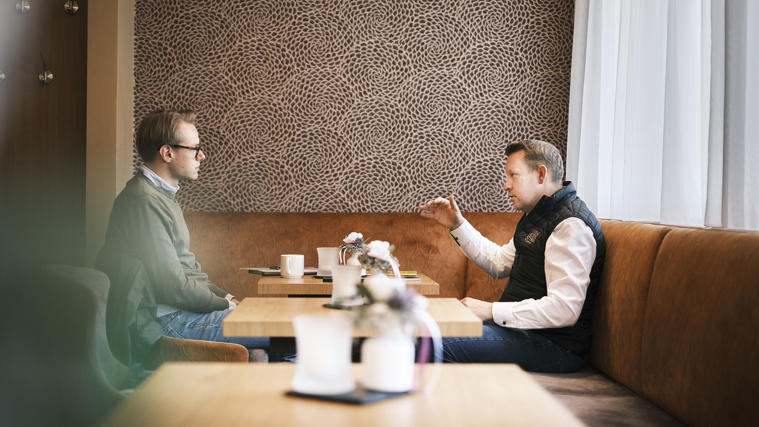 Zwei Personen unterhalten sich in einem Kaffee.