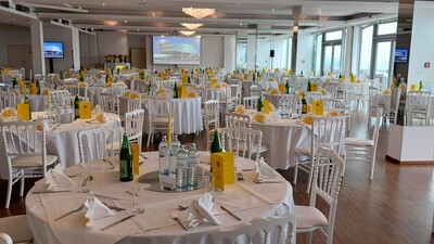 Das Foto zeigt runde Tische mit weißer Tischdecke und ebenfalls weißen Stühlen. Es handelt sich um den für die Mitglieder-Ehrung vorbereiteten Festsaal am Kahlenberg