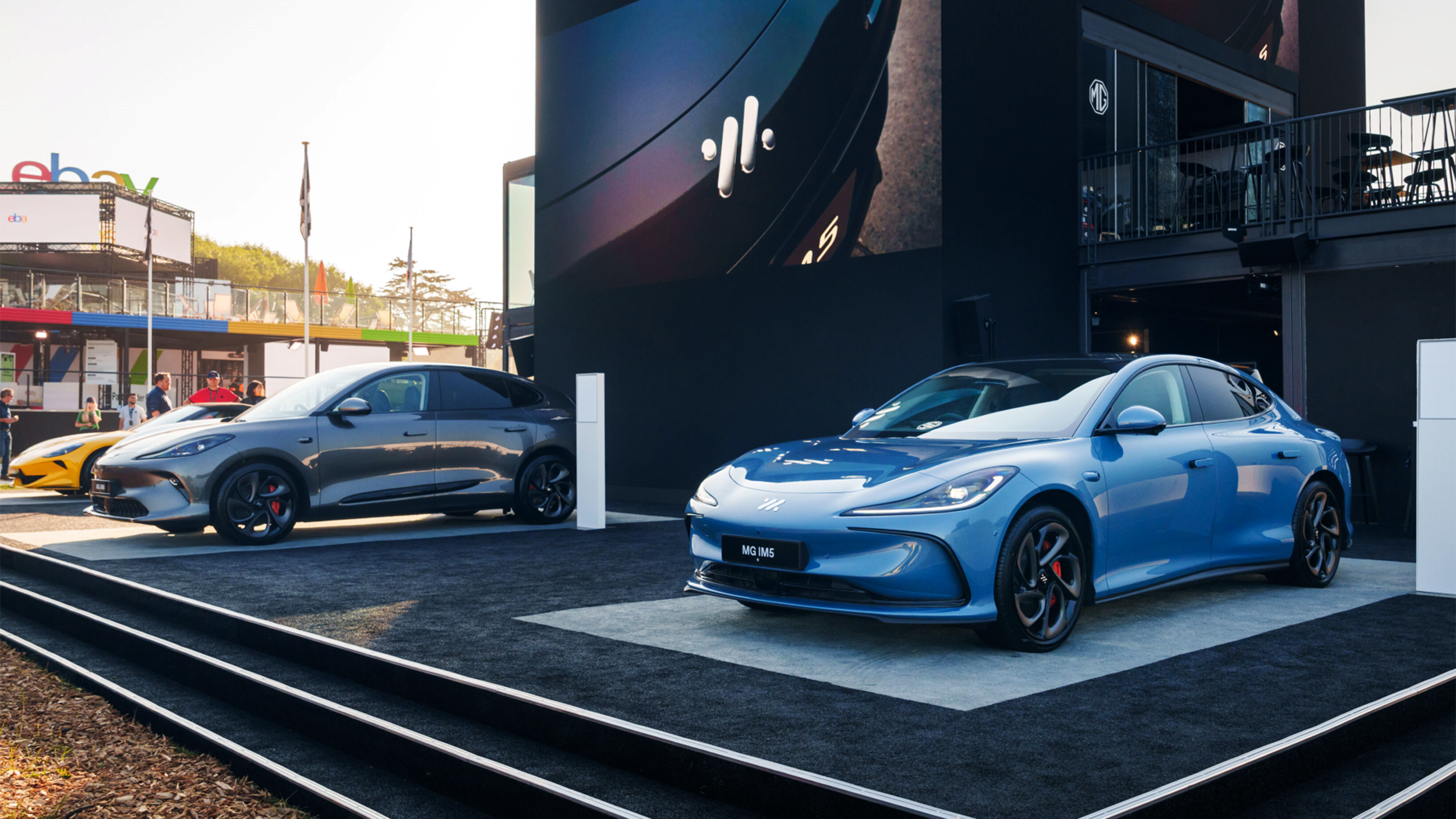 Ausstellungsstand der Marke MG mit drei Autos davor am Goodwood Festival of Speed.