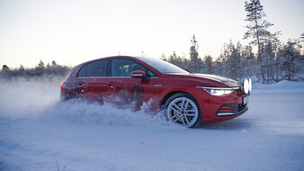 Jedes Jahr testet der ÖAMTC und seine Partnerorganisationen zahlreiche Winterreifen. Ein roter VW Golf fährt über eine Schneefahrbahn in einem Wald.