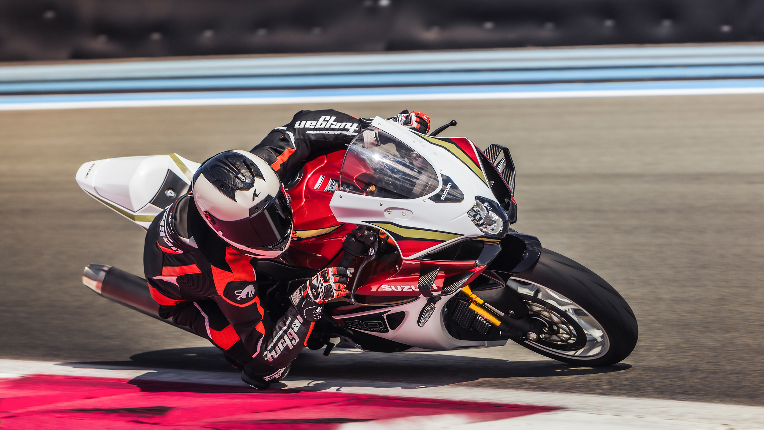 Ein rotes Motorrad fährt auf einer Rennstrecke durch die Kurve