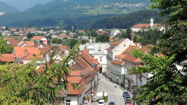 Blick auf die Hauptstraße von Kamnik (Slowenien) mit vorbeifahrenden Fahrzeugen
