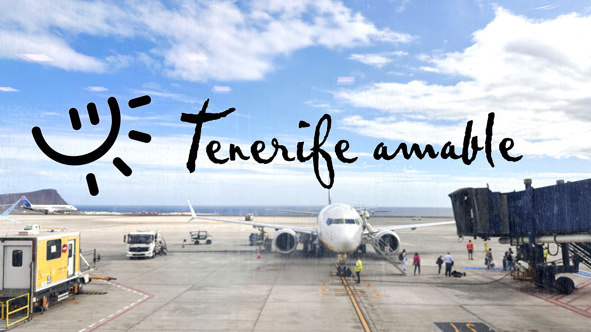  Eine große Scheibe aufs Rollfeld des Flughafens mit dem Text: Tenerife amable.