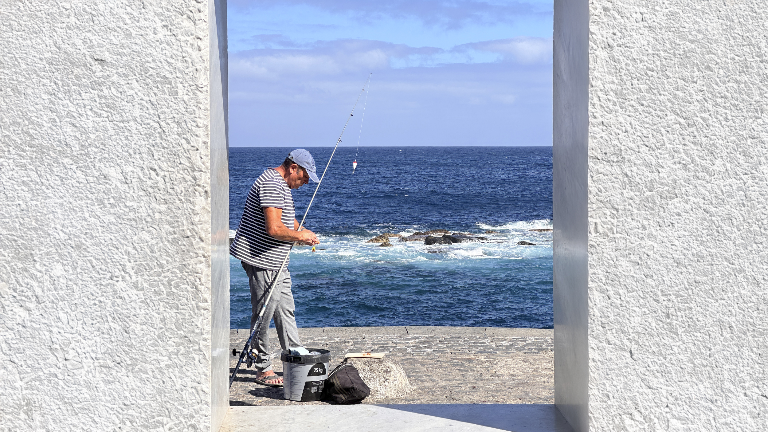 Ein Fischer macht gerade seinen Angelhaken fertig fürs Auswerfen.