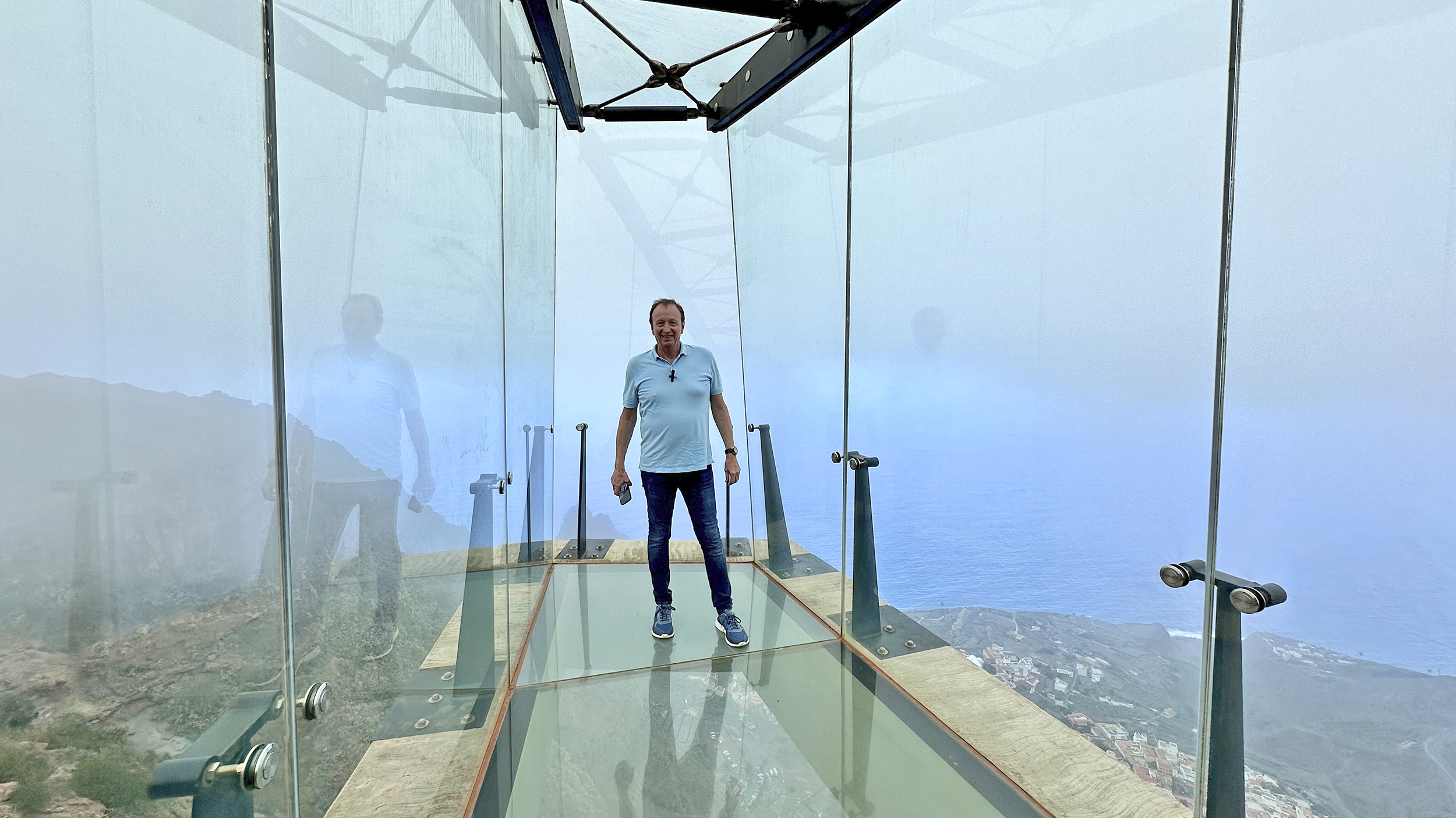 Der Reporter steht auf dem Glasboden des Aussichtsfingers, unter ihm geht es 600 Meter in die Tiefe.