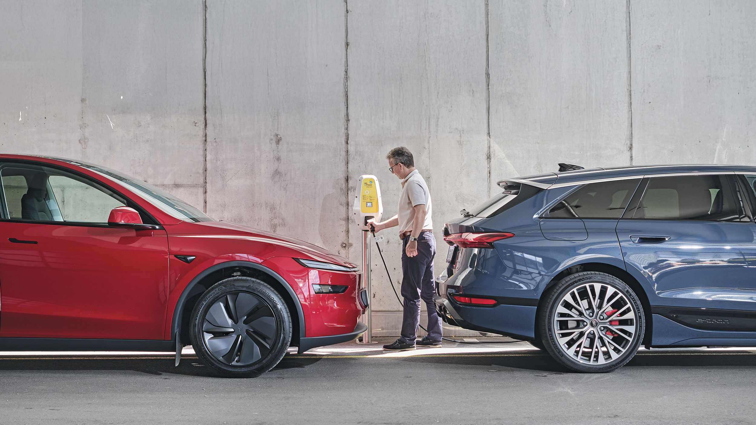 zwei elektroautos gegenüber stehend ein rotes und ein blaues