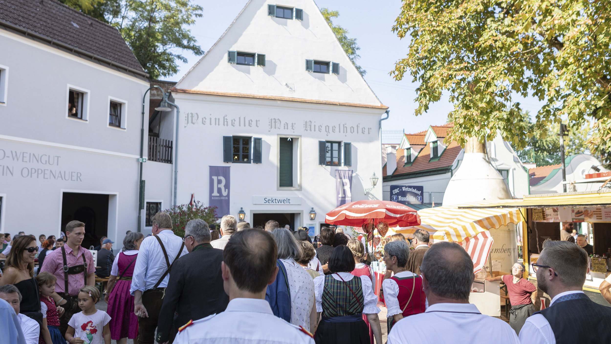 Viele Leute sind beim Winzerfest und stehen vor der Sektwelt Riegelhofer.