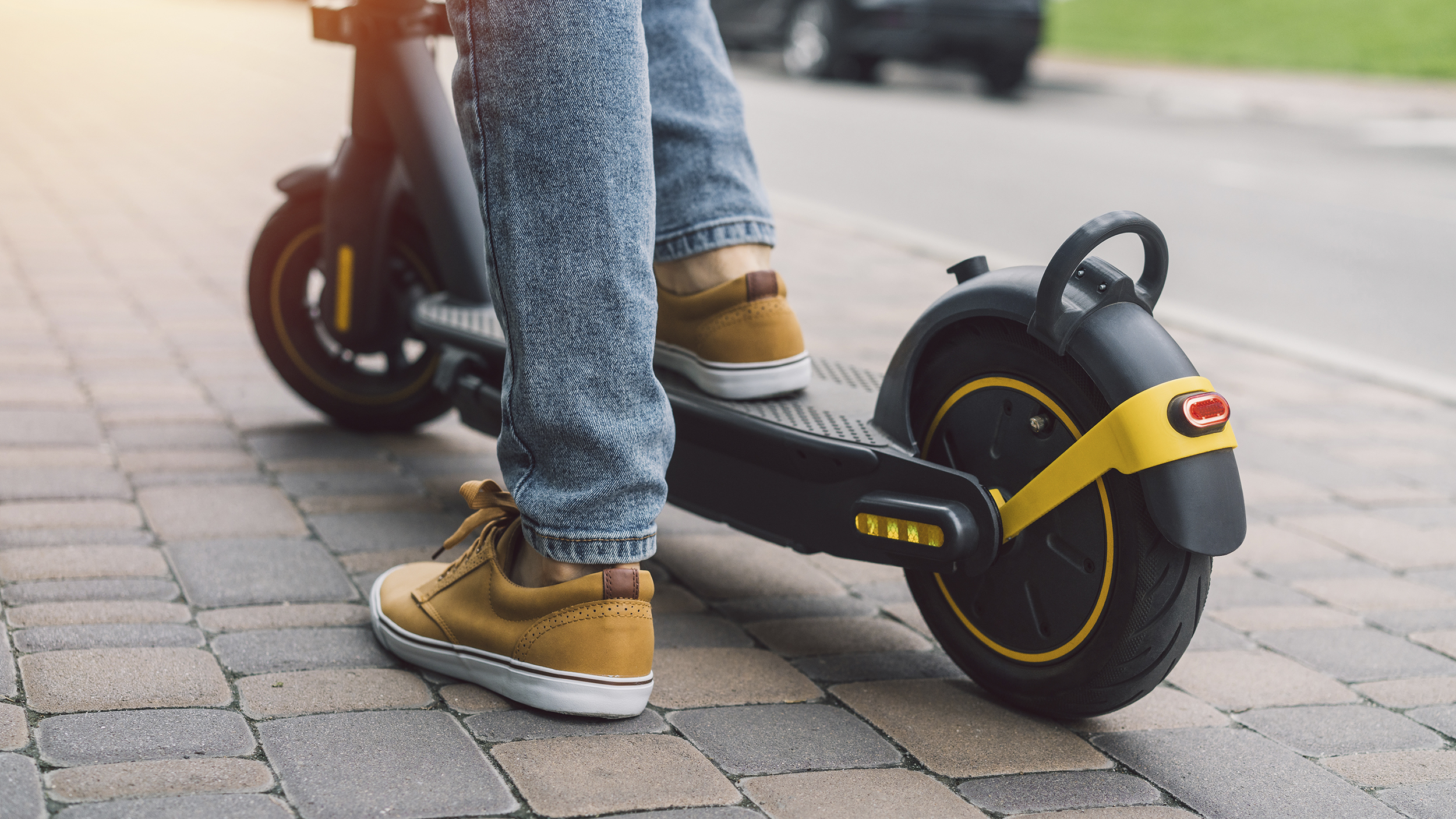 Jemand steht auf einem E-Scooter