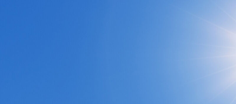 Auf dem Bild sieht man eine strahlende Sonne auf blauem Himmel.