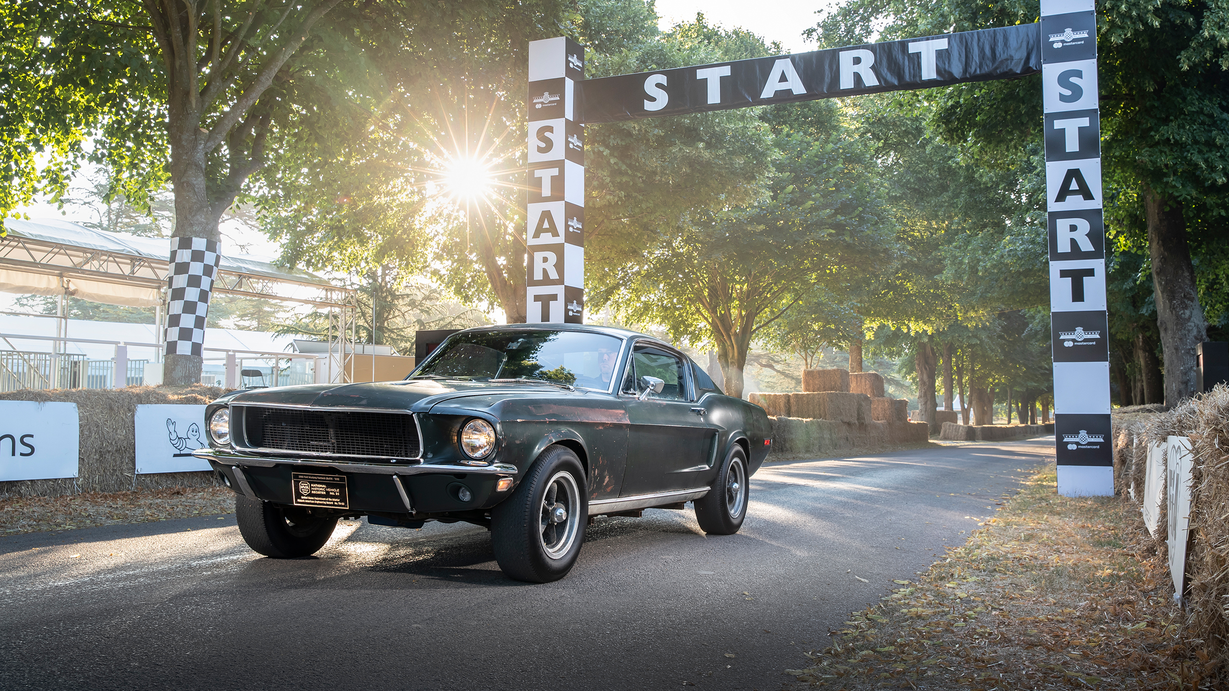 Ein dunkelgrüner Ford Mustang auf einer Rennstrecke