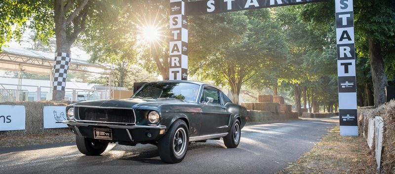 Ein dunkelgrüner Ford Mustang auf einer Rennstrecke