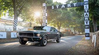 Ein dunkelgrüner Ford Mustang auf einer Rennstrecke