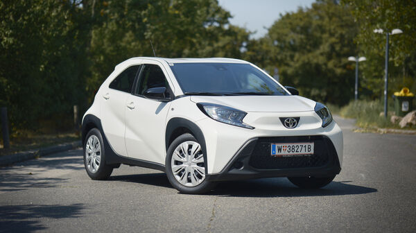Ein weißer Toyota Kleinwagen steht auf einer Straße