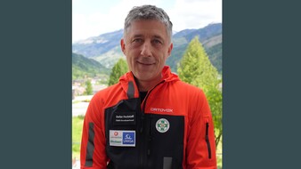 Portraitfoto von Stefan Hochstaffl. Er trägt eine schwarz-rote Jacke auf der das Logo der Österreichischen Bergrettung zu sehen ist.