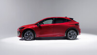Ein roter Renault Clio in einem weißen Raum von der Seite