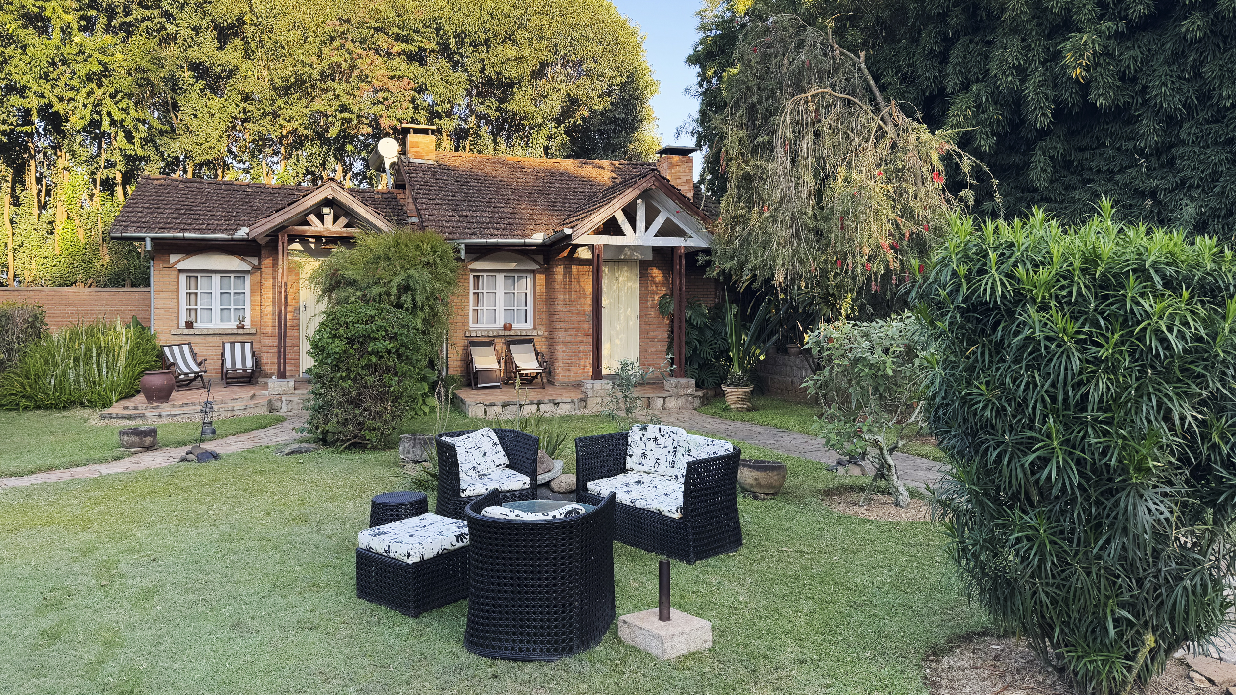 Französiches Cottage mit einer Sitzgelegenheit im Garten.