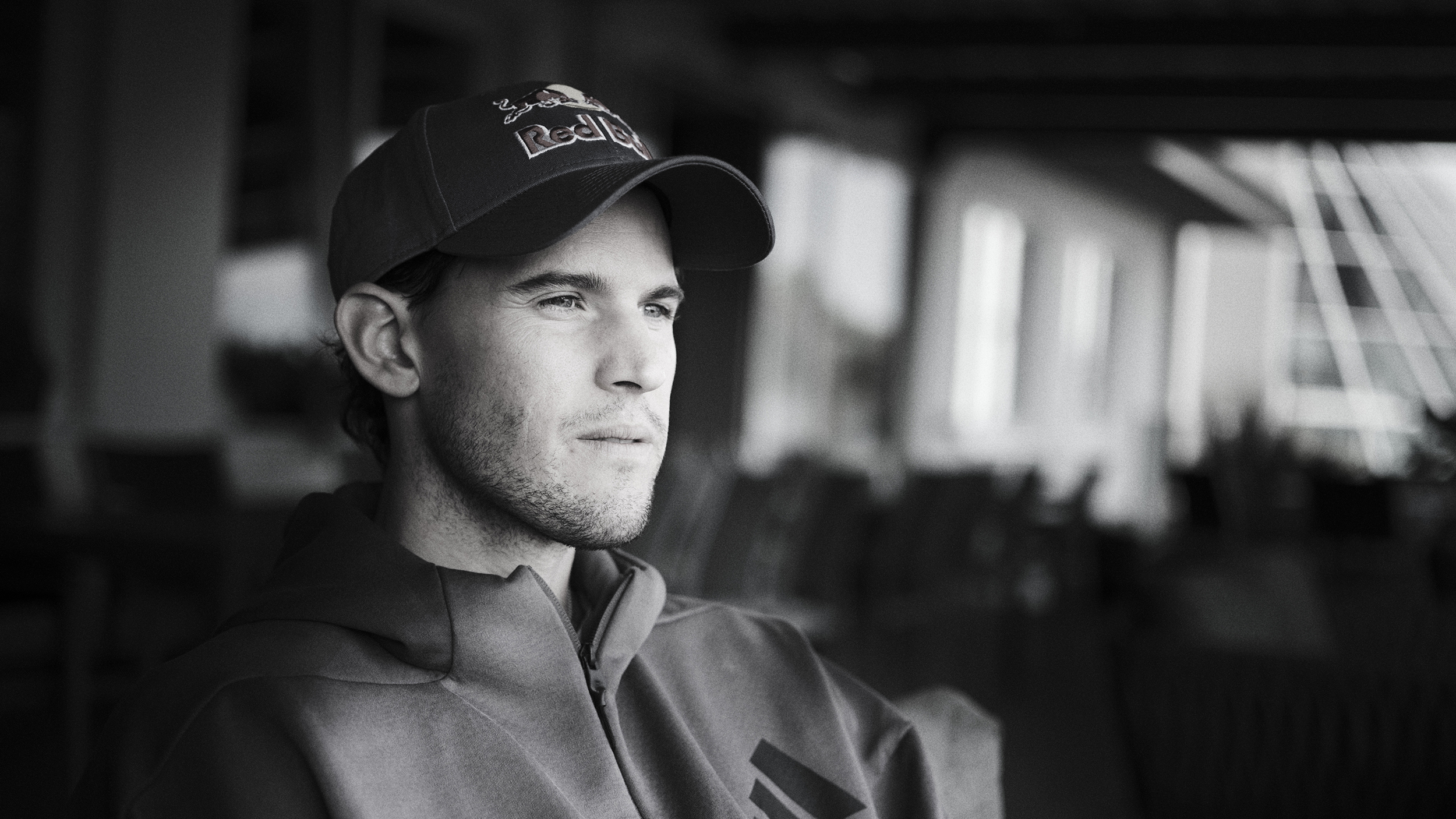 Schwarz-weiß-Foto des Ex-Tennisspielers Dominic Thiem, wie er in die Ferne blickt.