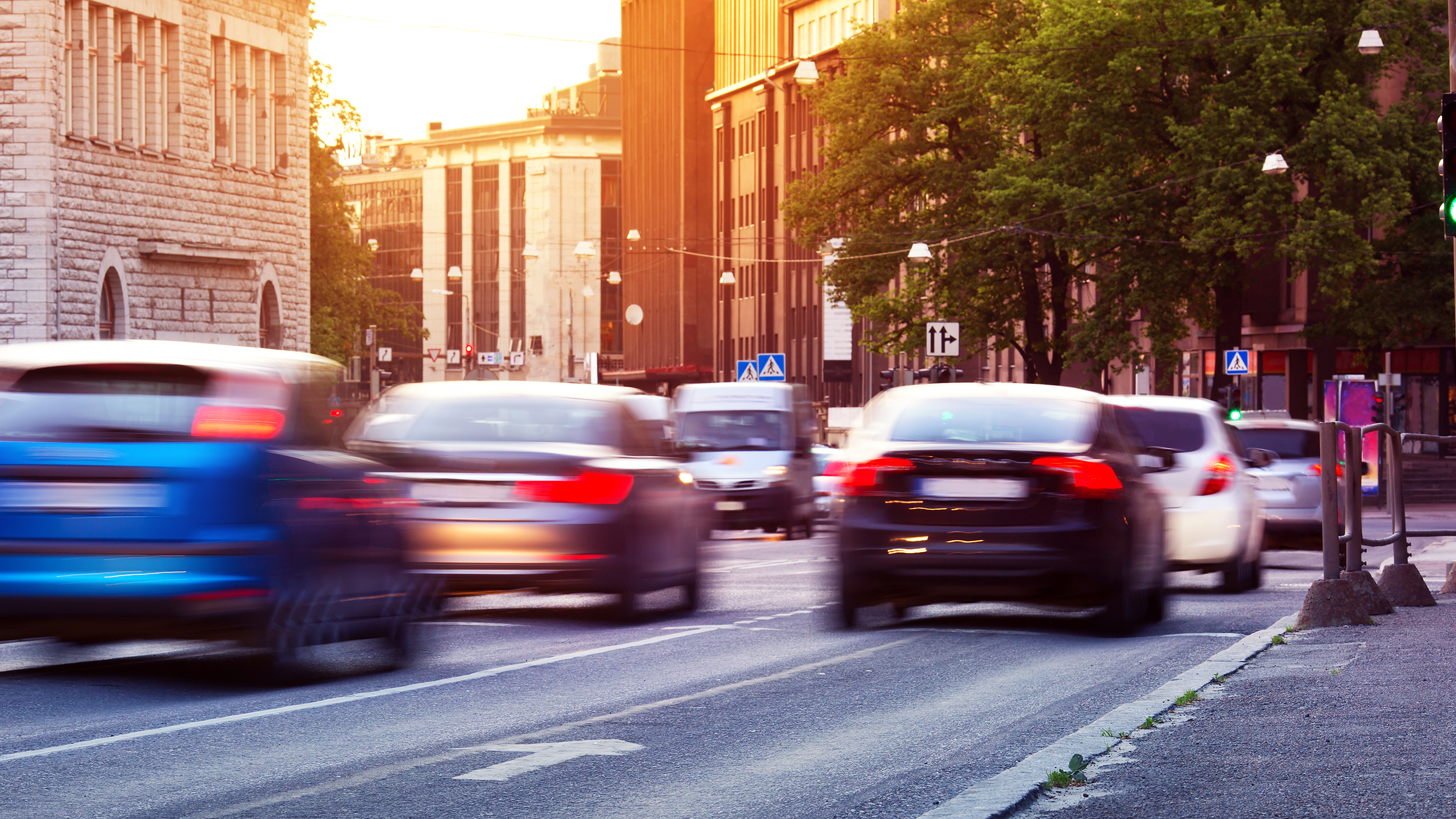 Autos fahren bei Sonnenuntergang durch die Stadt