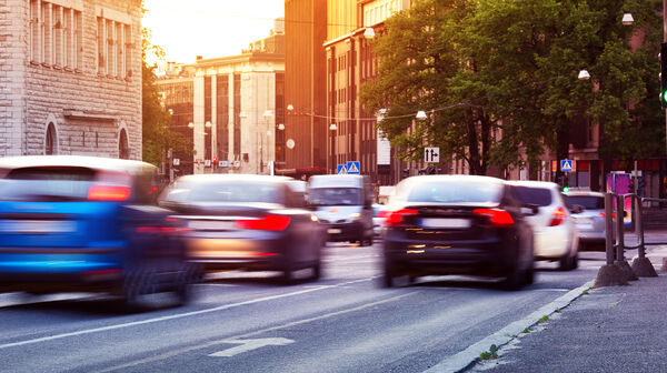 Autos fahren bei Sonnenuntergang durch die Stadt