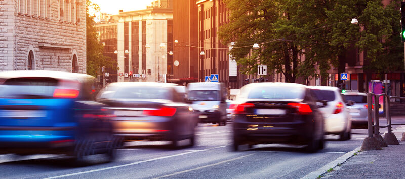Autos fahren bei Sonnenuntergang durch die Stadt