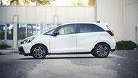 Ein weißer Honda Jazz seitlich vor einem Haus