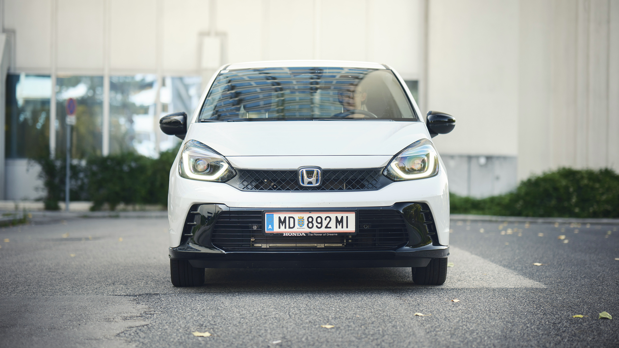 Ein weißer Honda Jazz steht vor einem Haus