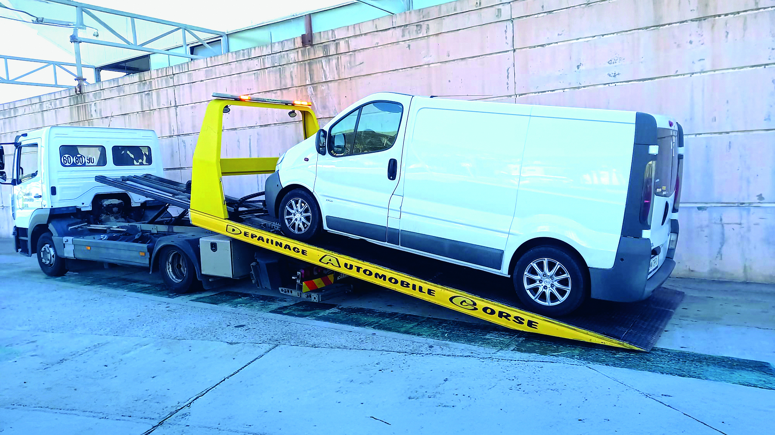 Ein Camping-Kastenwagen auf der Ladefläche eines Abschleppautos. 