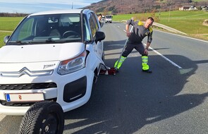 Das Bild zeigt ein weißes Auto, das eine Panne hat und Pannenfahrer Andi, der das Fahrzeug mustert.