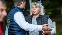 Auf dem Bild sieht man eine Frau im Gespräch mit einem Mann. Den Mann sieht man nur von hinten, die Frau von vorne.